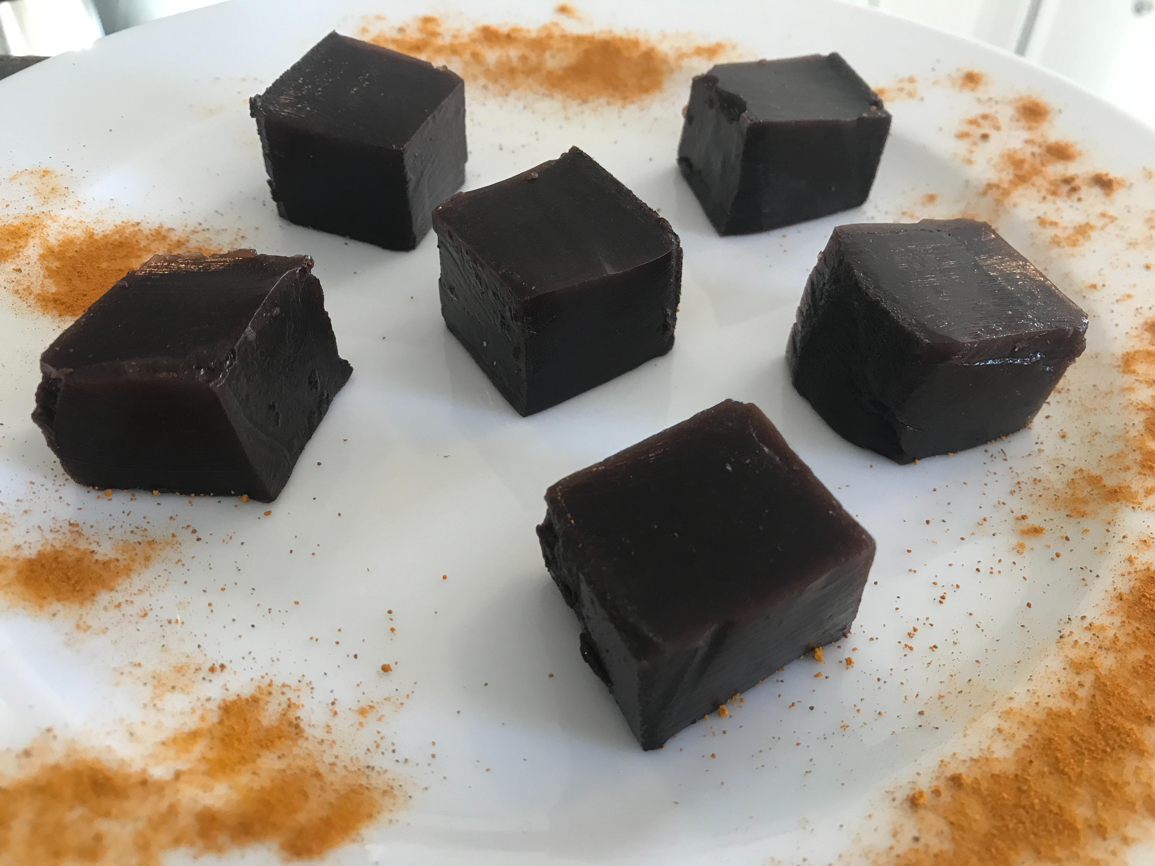 Six blocks of HANAH Collagen Boosting Blocks on a white plate dusted with cinnamon