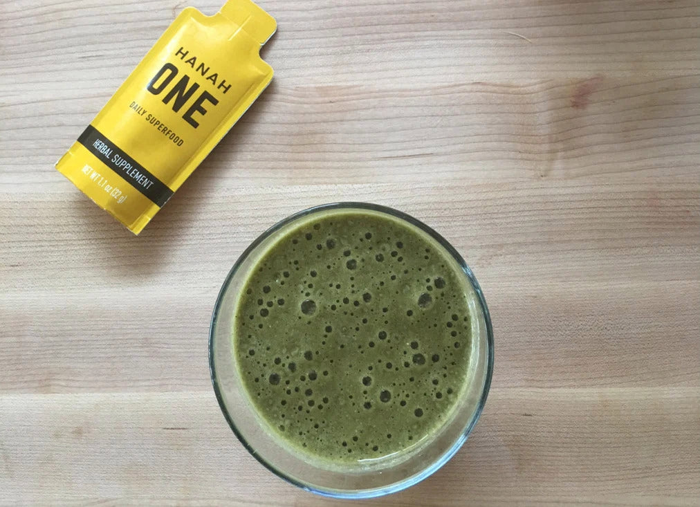 Glass of green smoothie by Taylor Winters next to a HANAH ONE Go Pack