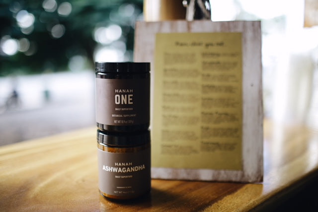 Adaptogen Powerhouse Bundle including HANAH ONE and Ashwagandha on a table in front of a menu