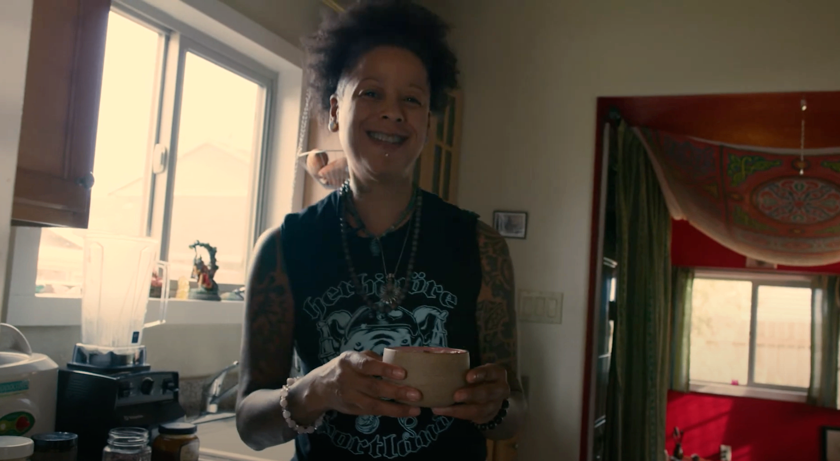 HANAH Hero Bibi McGill stands in her kitchen and holds a cup of her delicious and nutritious adaptogenic tea made with HANAH Ashwagandha