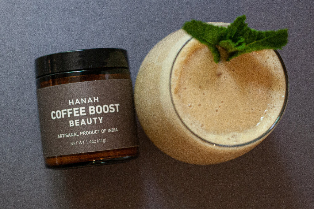Jar of HANAH Coffee Boost Beauty, an artisanal product, next to a latte drink