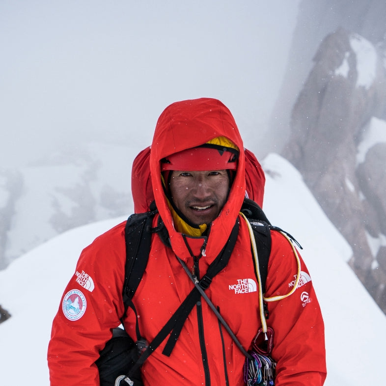 HANAH Hero Jimmy Chin in bright red gear on a snowy mountain. Photo by Conrad Anker