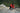 Award winning filmmaker and photographer Jimmy Chin climbing a vertical rock face with his camera slung over his shoulder